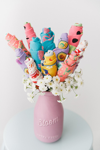 A finished bouquet of sock flowers in a vase with other real flowers